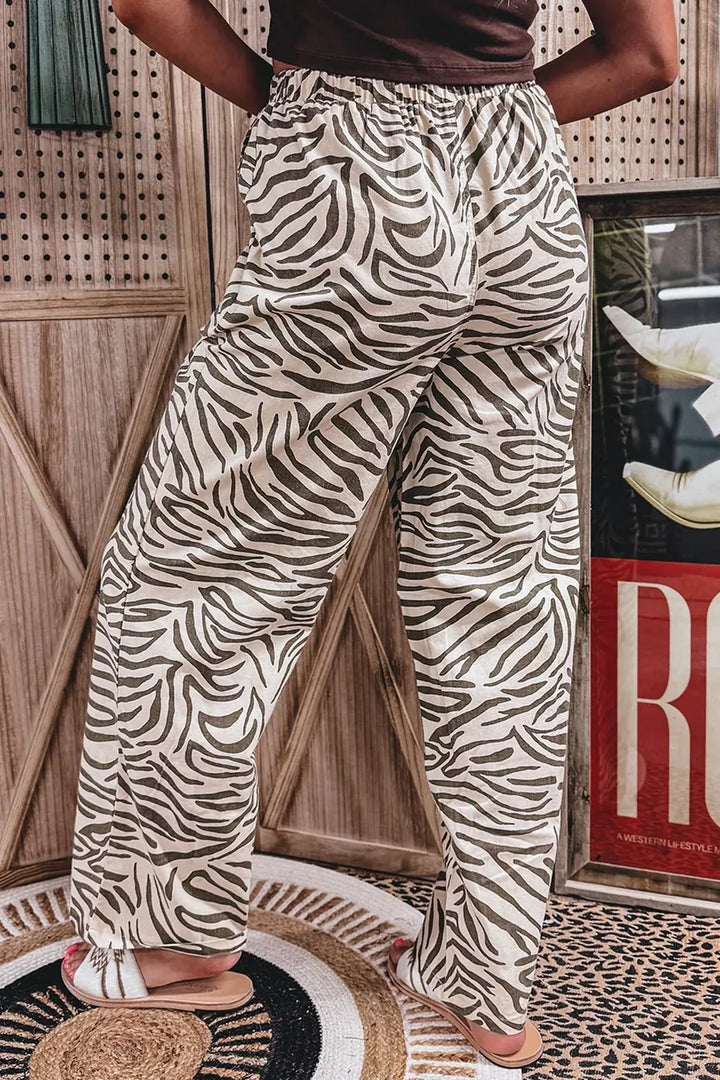 Zebra print drawstring pants seen from behind with hands on hips