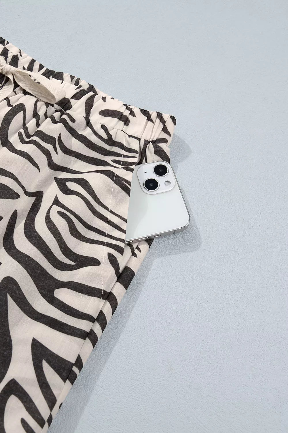 Zebra print pants side pocket with a phone tucked inside