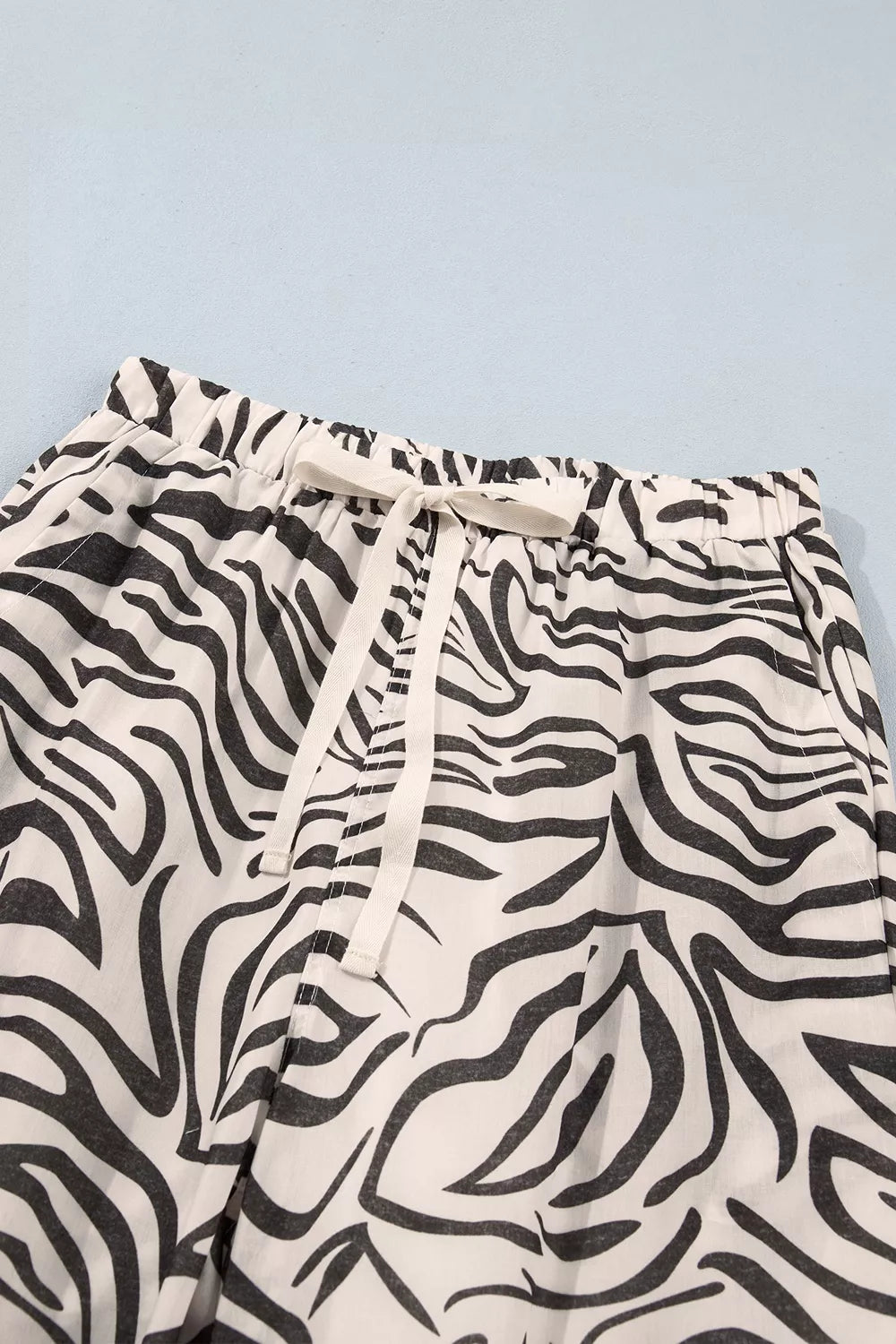 Zebra print pants drawstring waistband tied in a bow, close-up