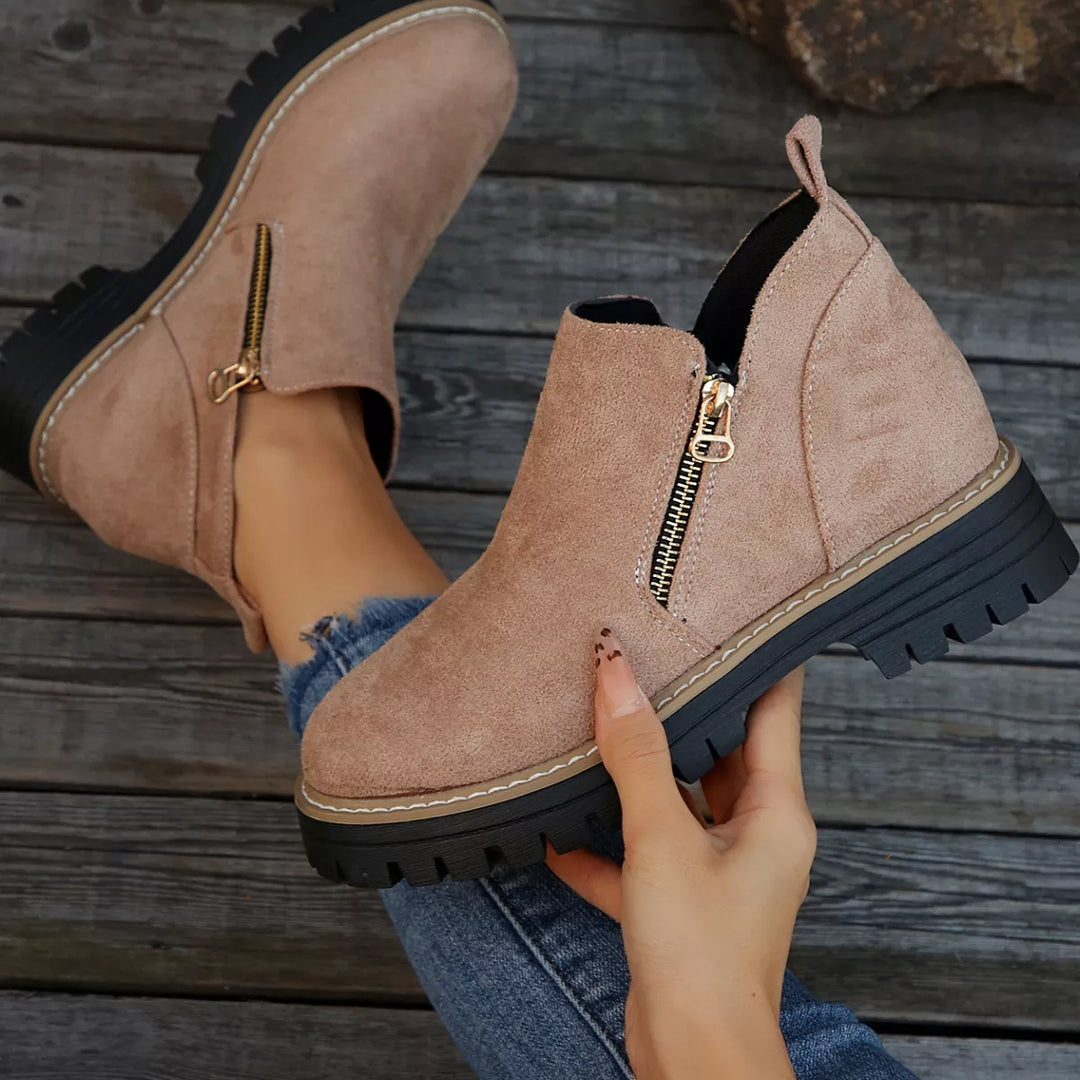 Dusty rose zipper boot held up to show the block heel and thick sole