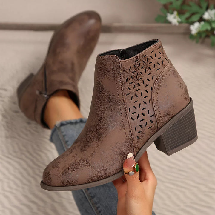 Close-up of brown ankle boots with cut out pattern and block heel