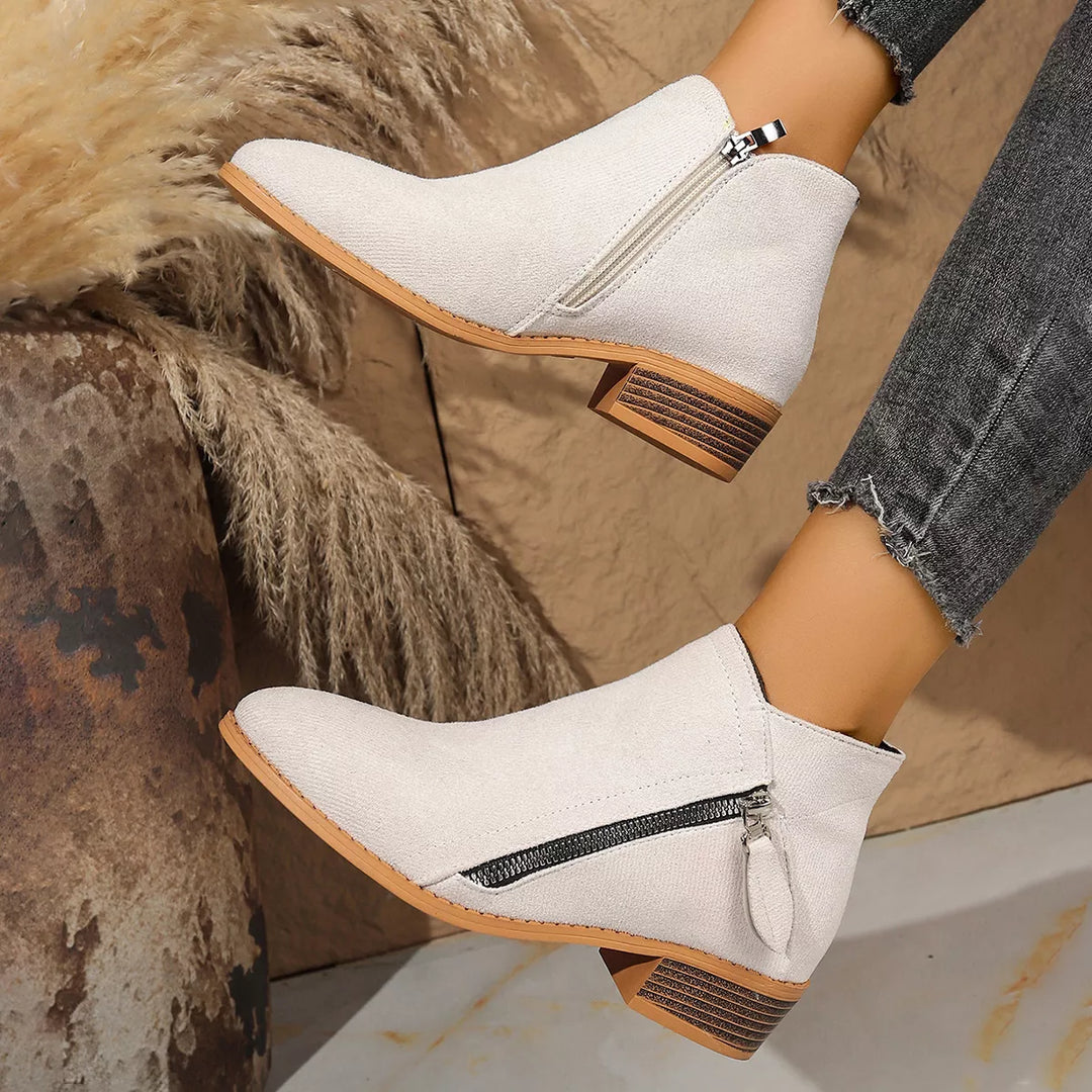 Cream ankle boots with side zip worn with gray jeans
