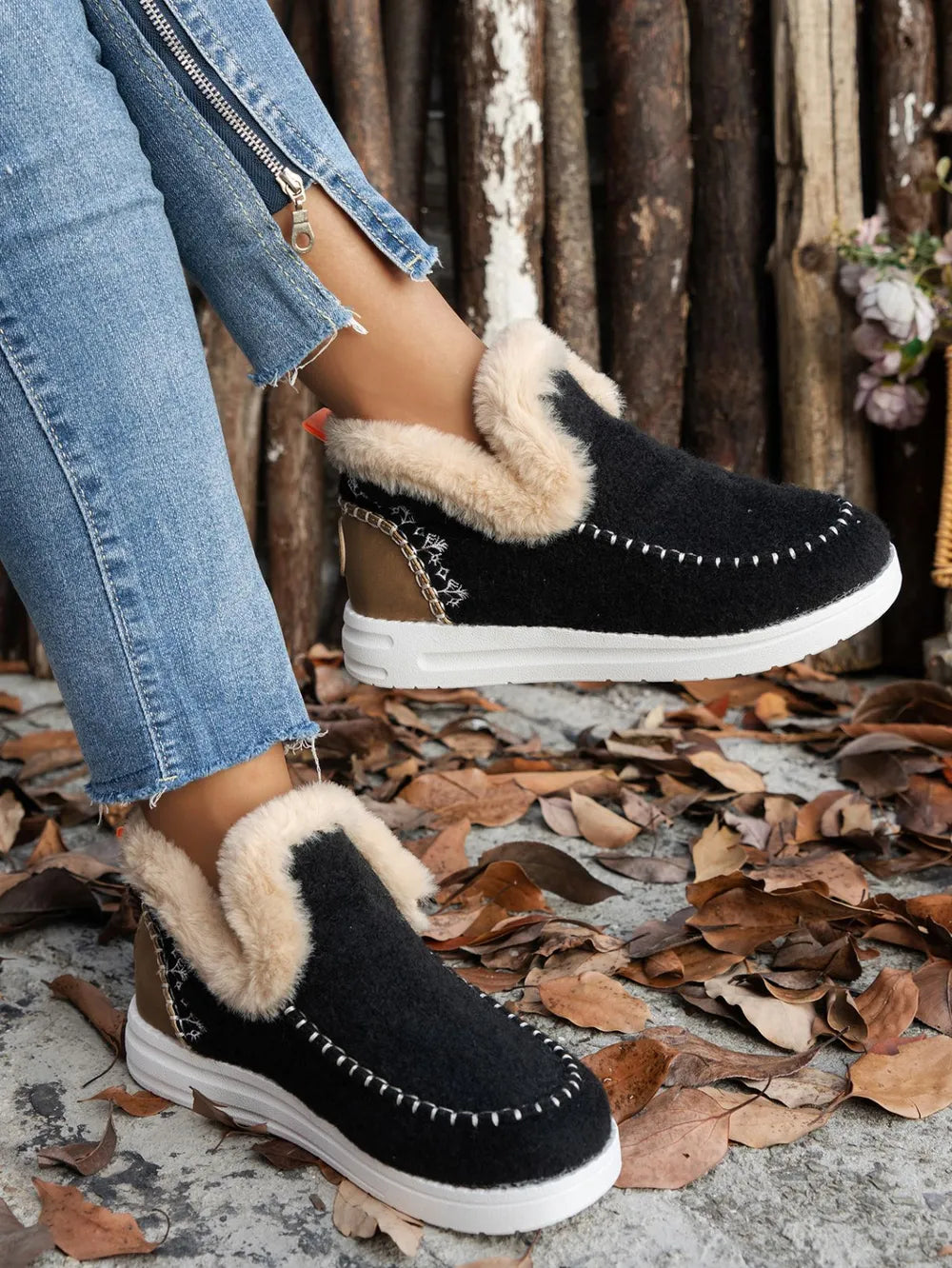 Black slip on ankle boot with studded trim, angled side view on foot