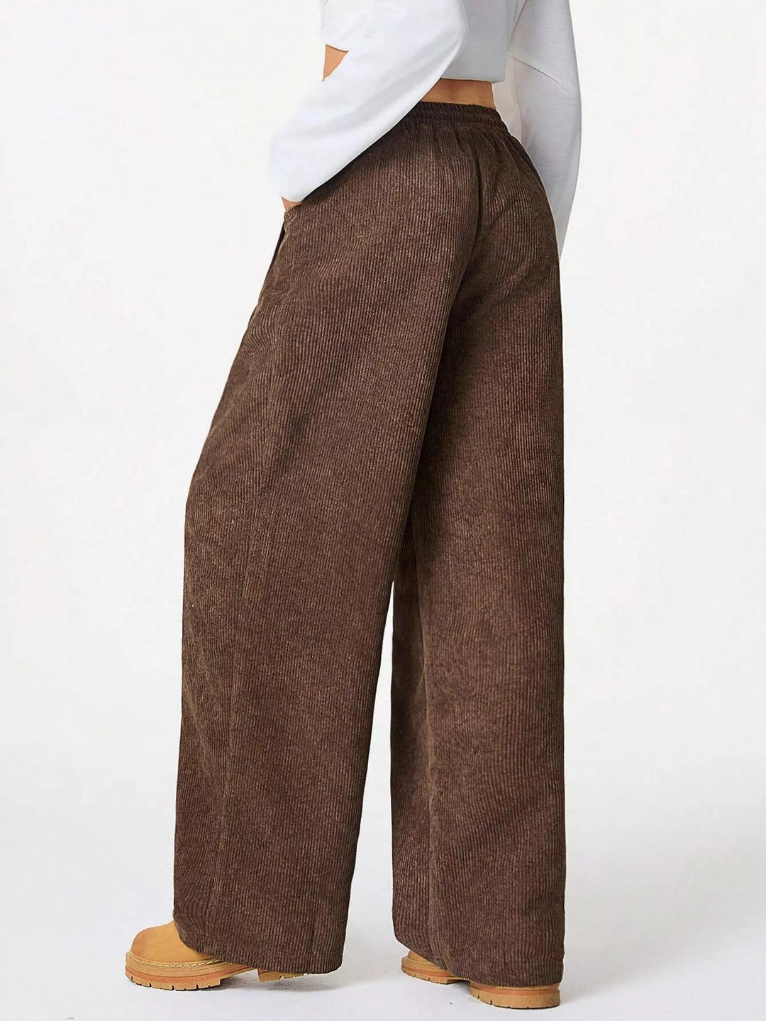 Side view of brown baggy pants with relaxed wide legs