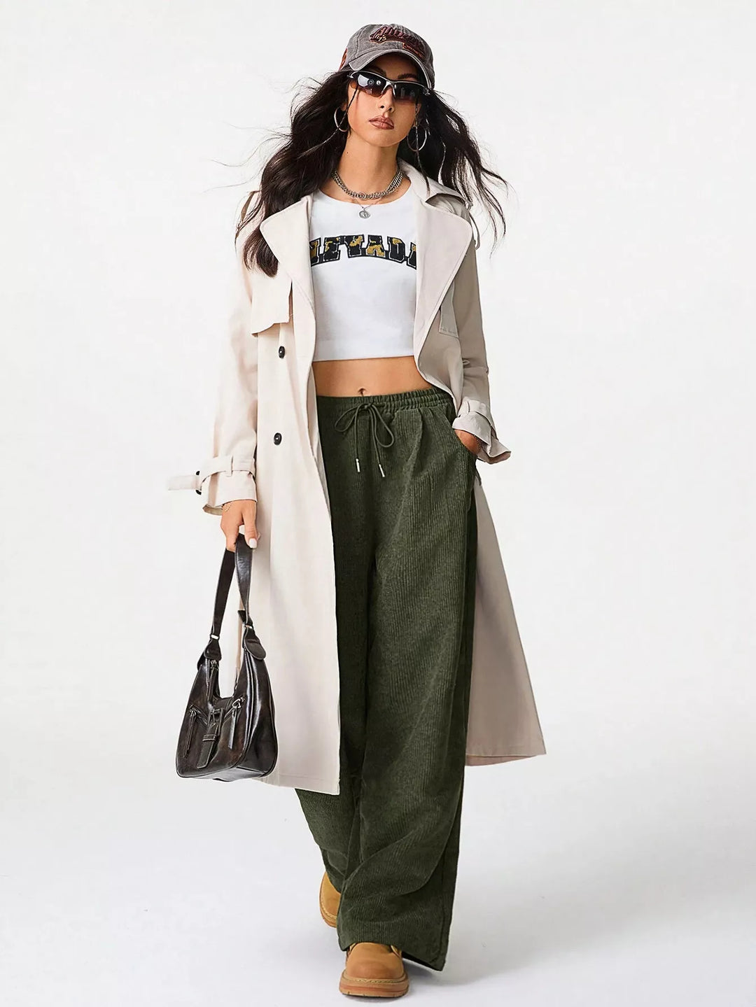 Olive baggy pants styled with a crop top, trench coat and handbag