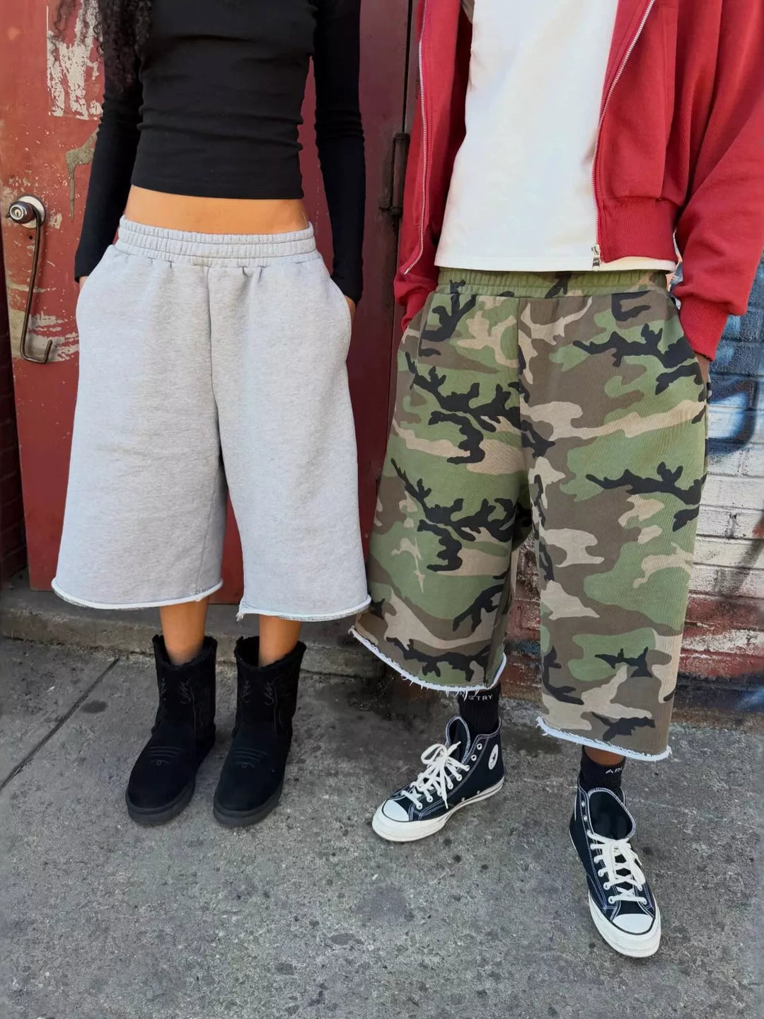 Woodland camo baggy shorts next to light gray shorts on two people