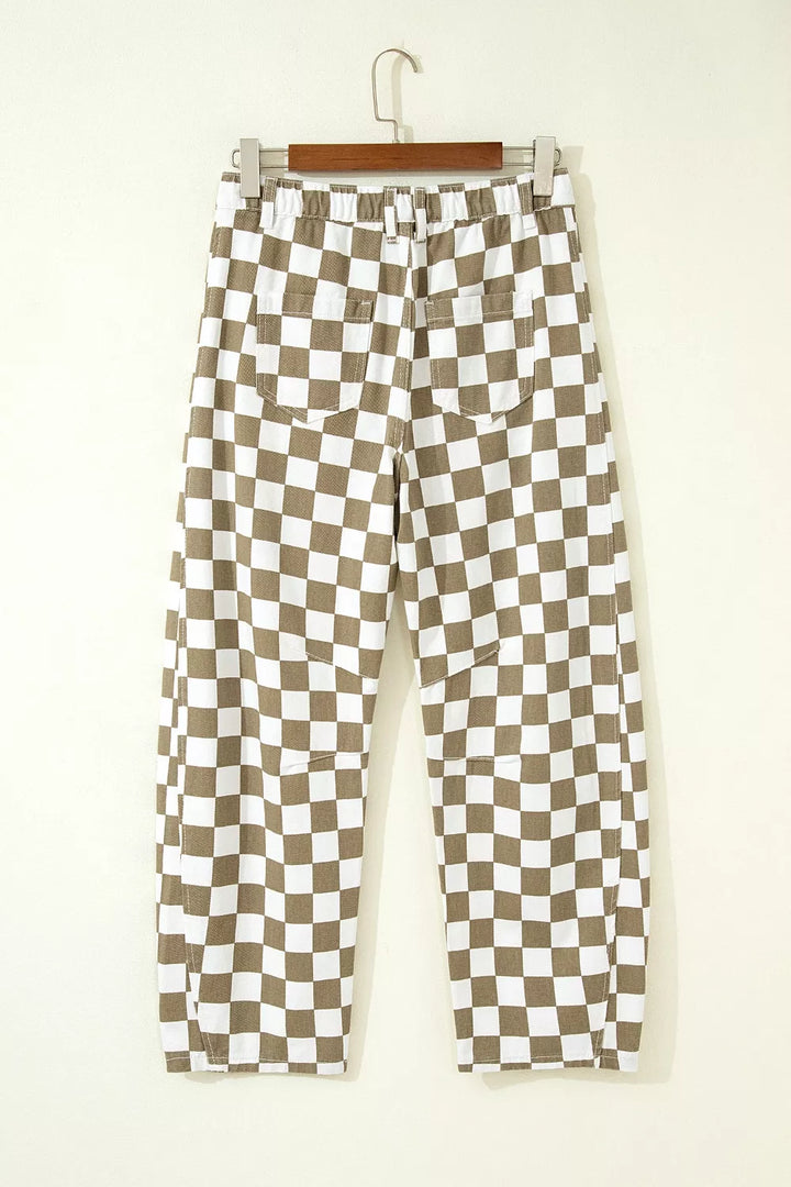 Back view of the khaki checkerboard pants hanging on a wooden hanger