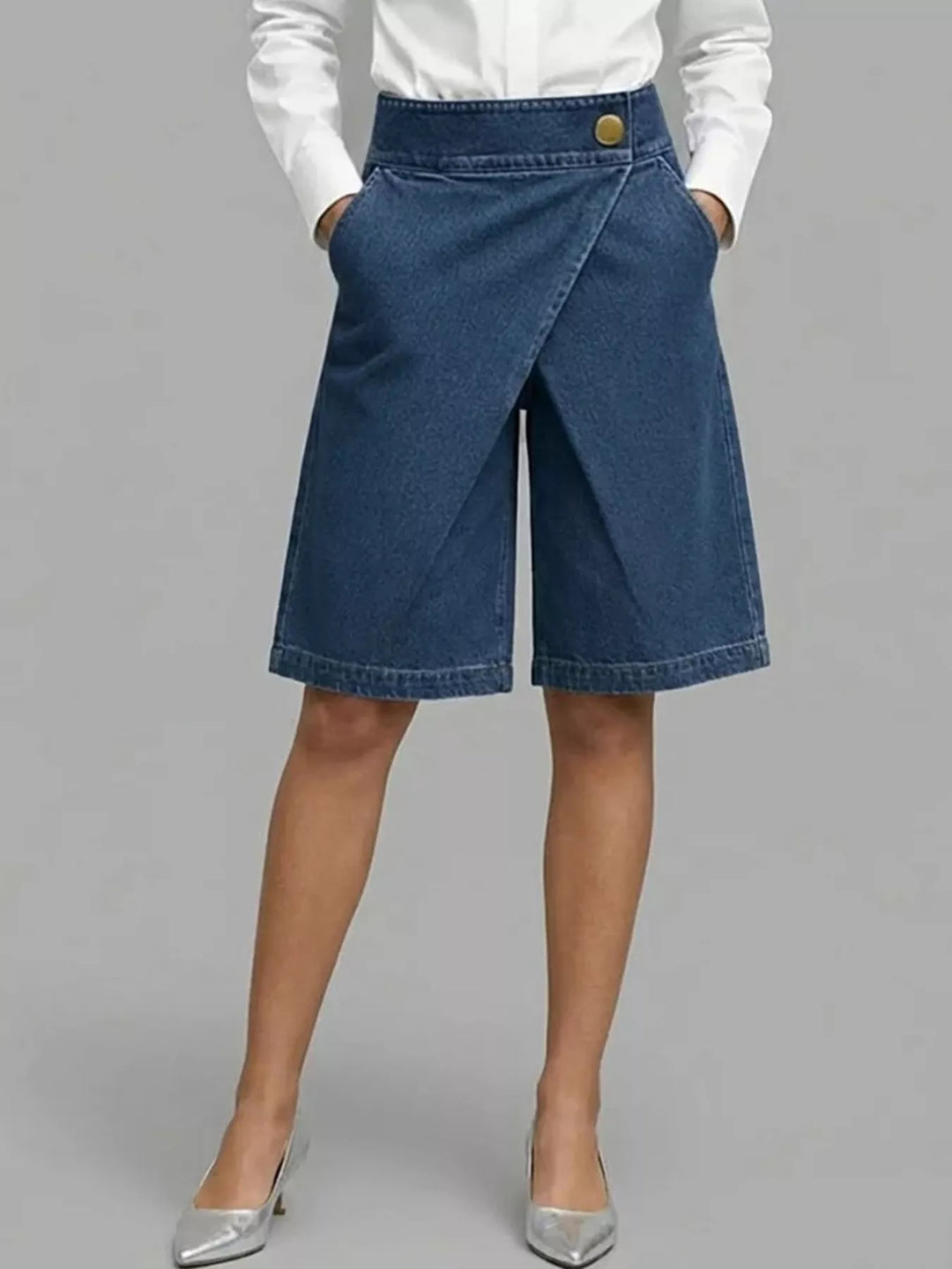 Navy wrap front Bermuda shorts worn with a white shirt and silver pumps
