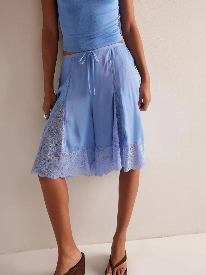 Full-length view of light blue Bermuda shorts worn with heeled sandals