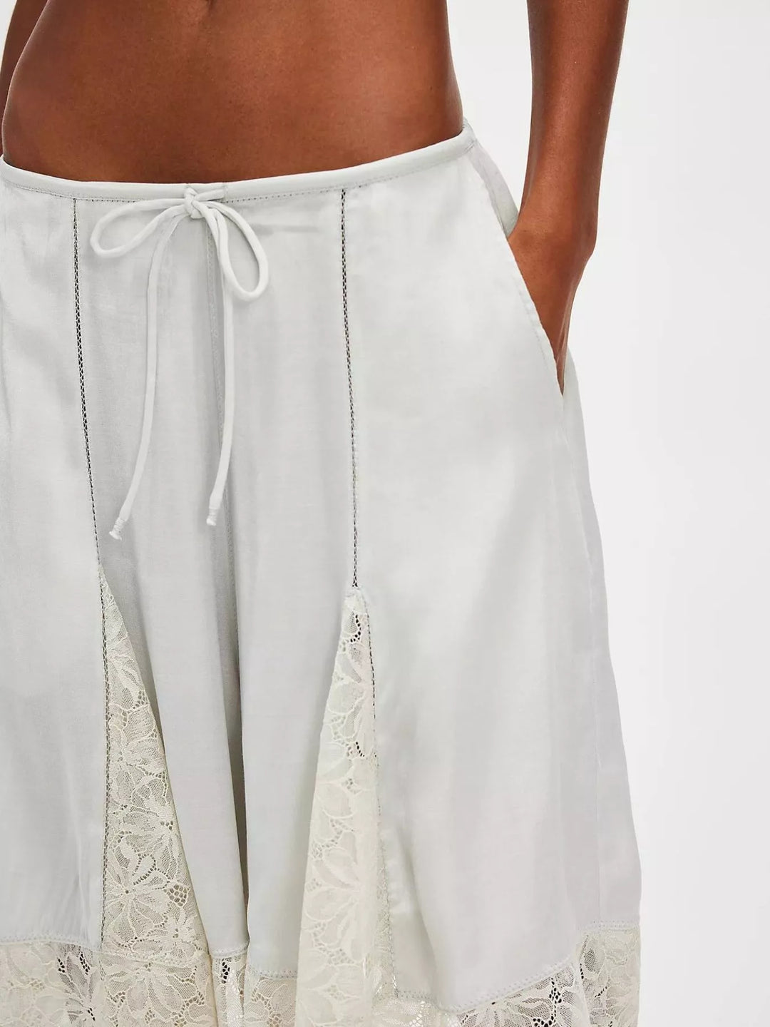 Close-up of light gray Bermuda shorts with lace insert and drawstring