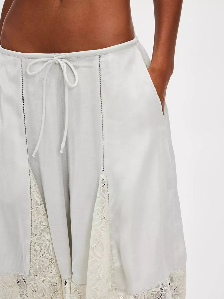 Close-up of light gray Bermuda shorts with lace insert and drawstring