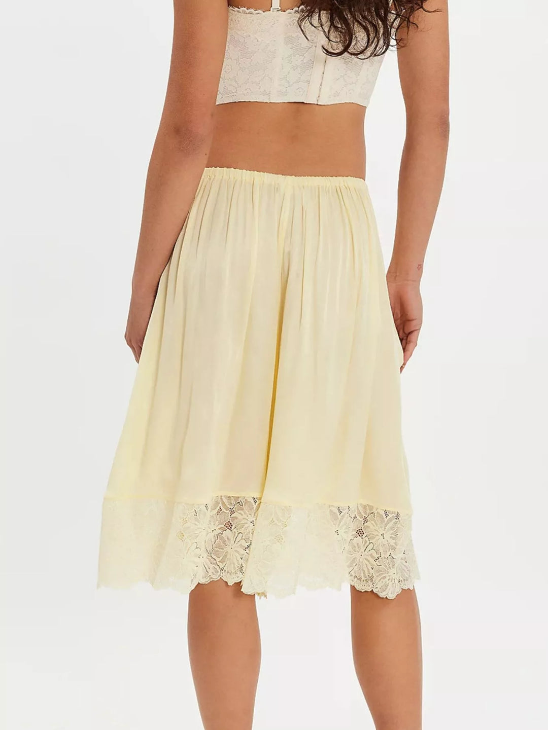 Back view of pastel yellow Bermuda shorts with lace hem