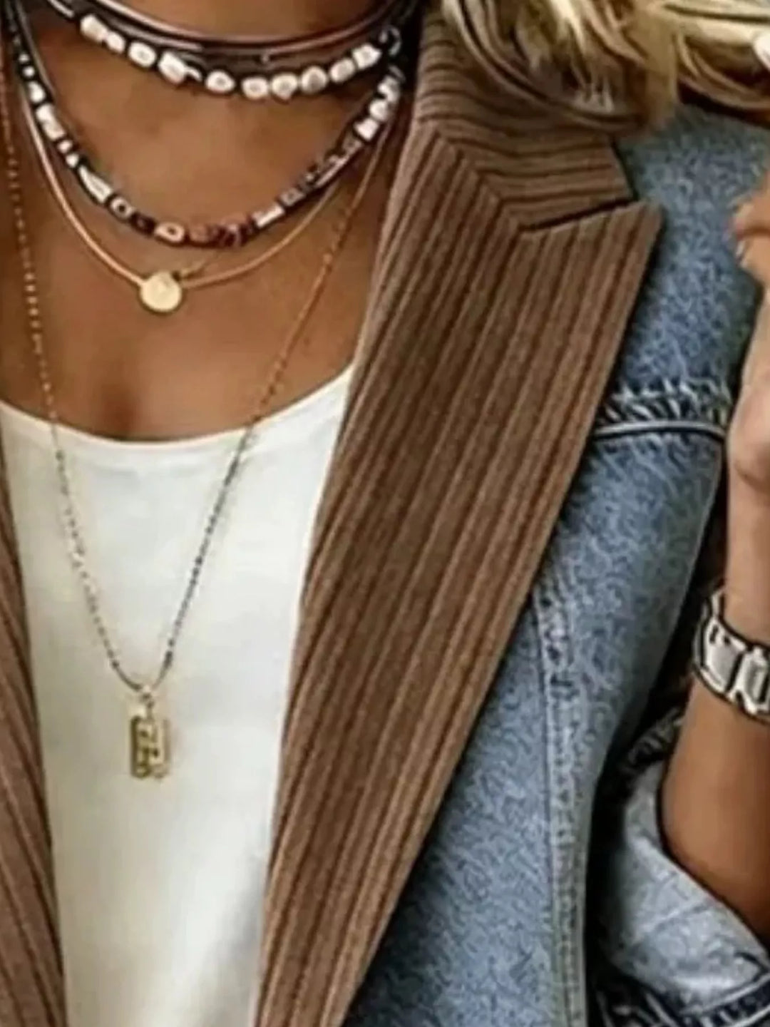 Close-up of brown blazer lapel with ribbed texture and denim panel