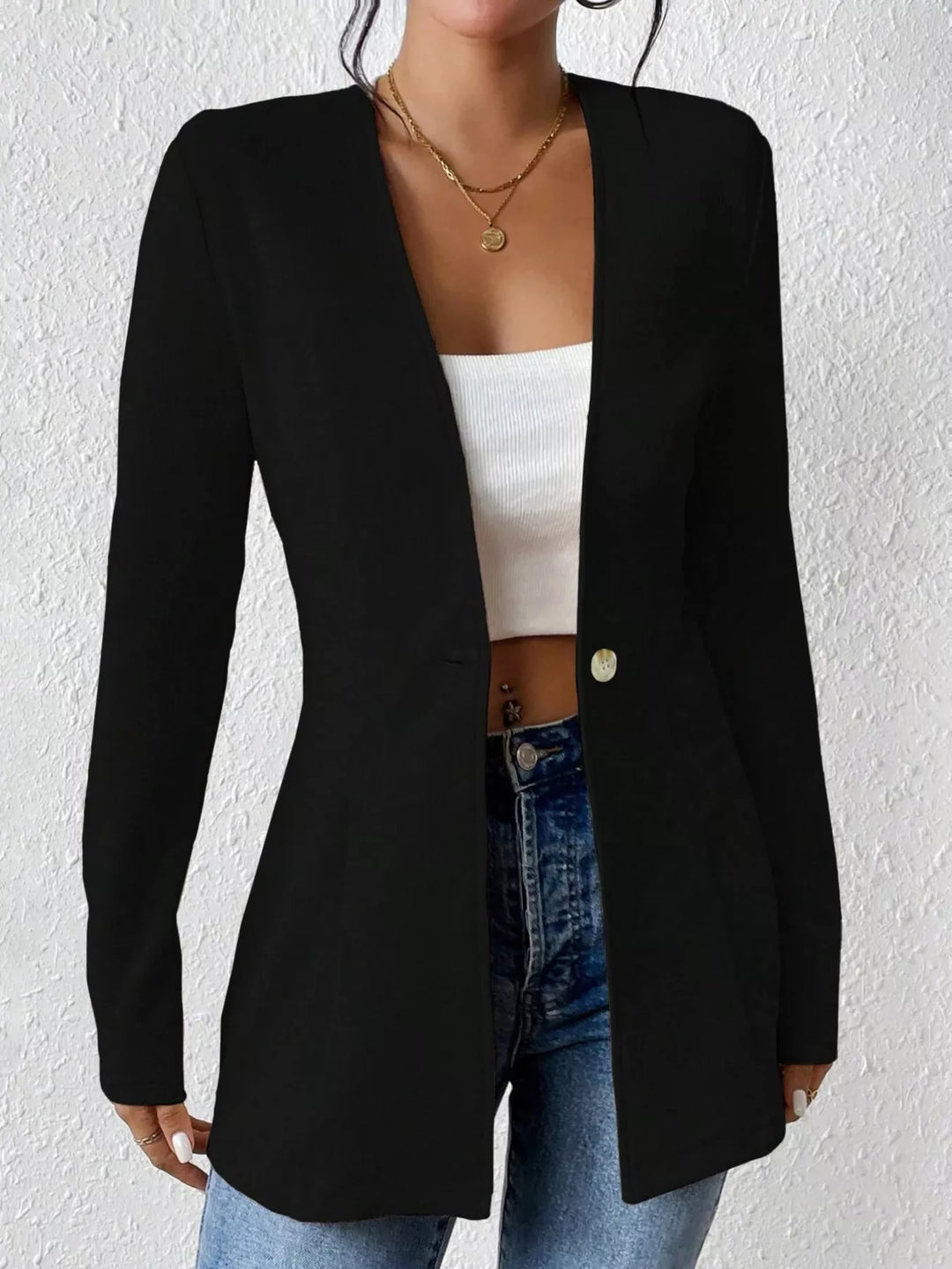 Black open front blazer with V neck, worn over a white crop top