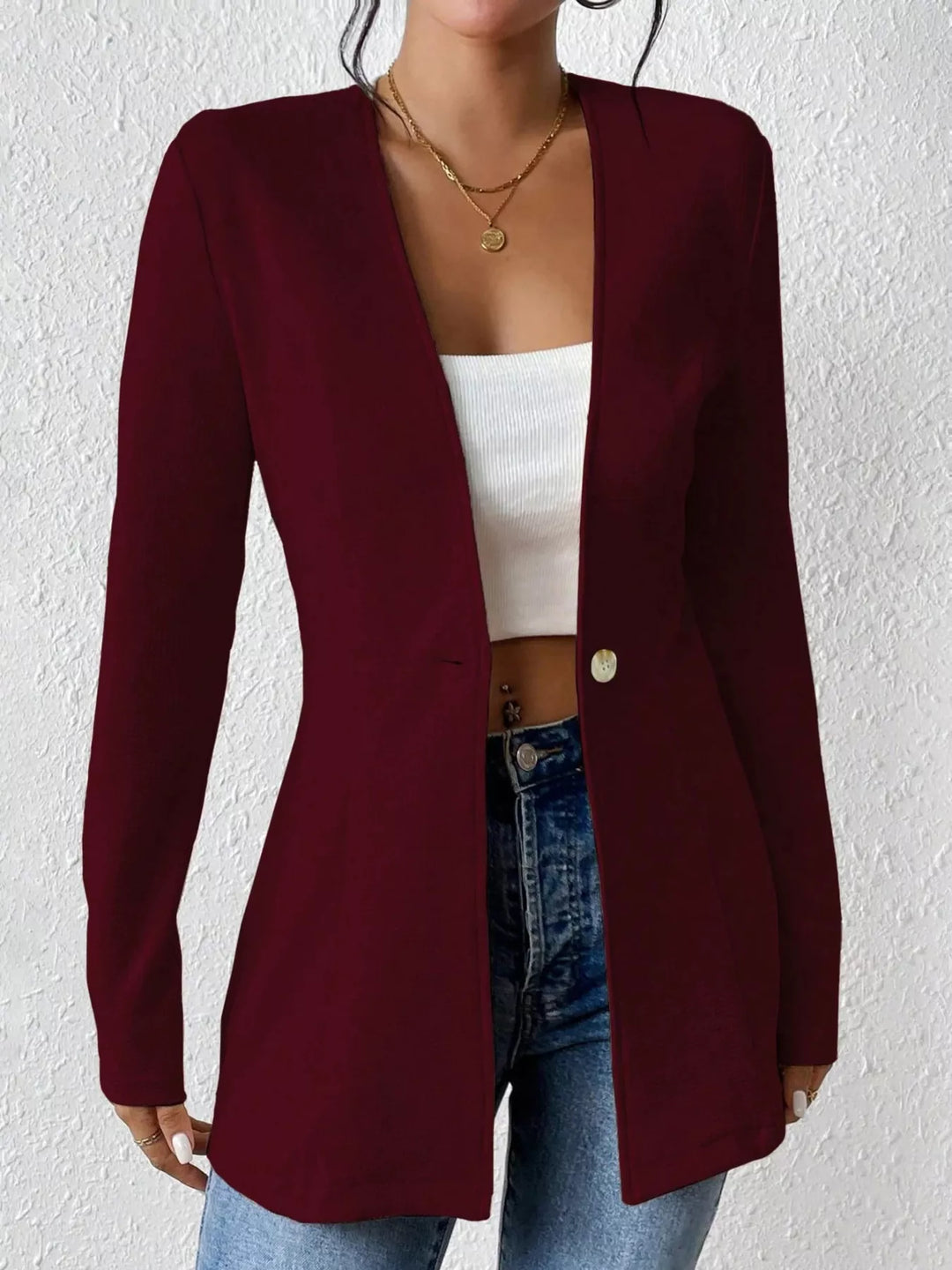 Burgundy collarless blazer worn open over a white top
