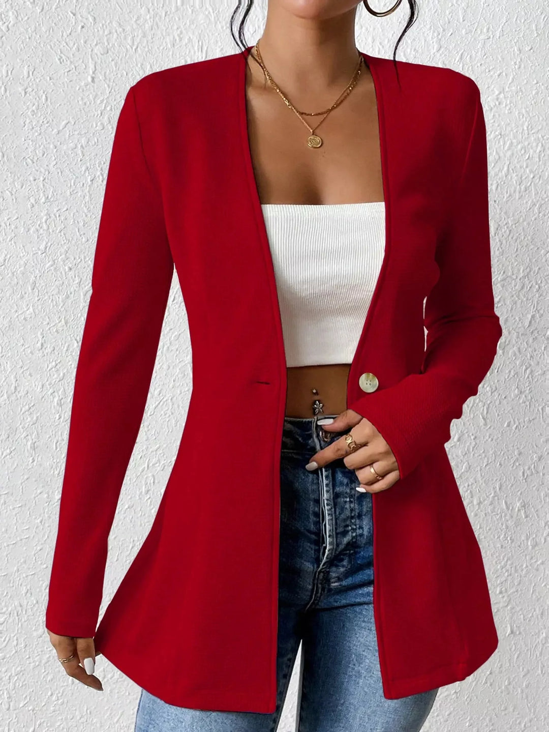 Red one button blazer worn open, close view of the waist and button
