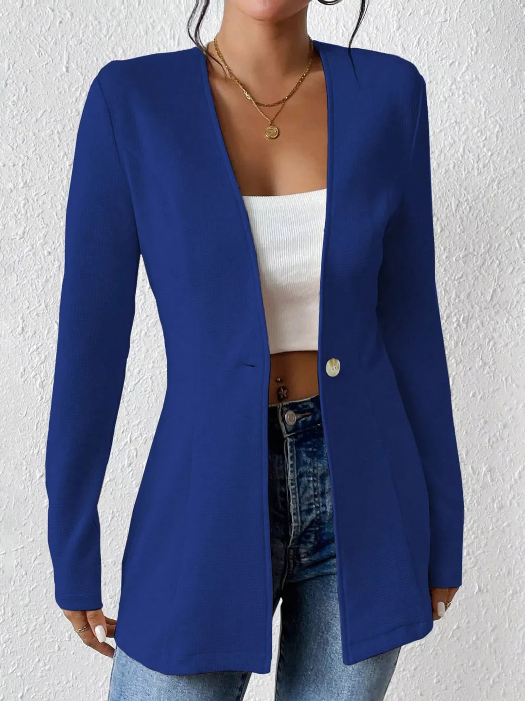 Royal blue collarless blazer worn open over a white top and jeans