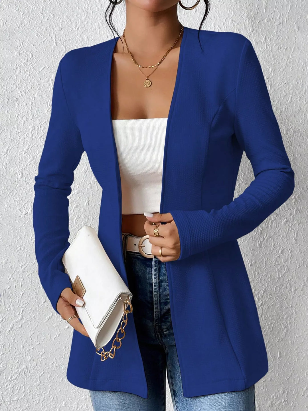 Royal blue open front blazer styled with a white clutch bag