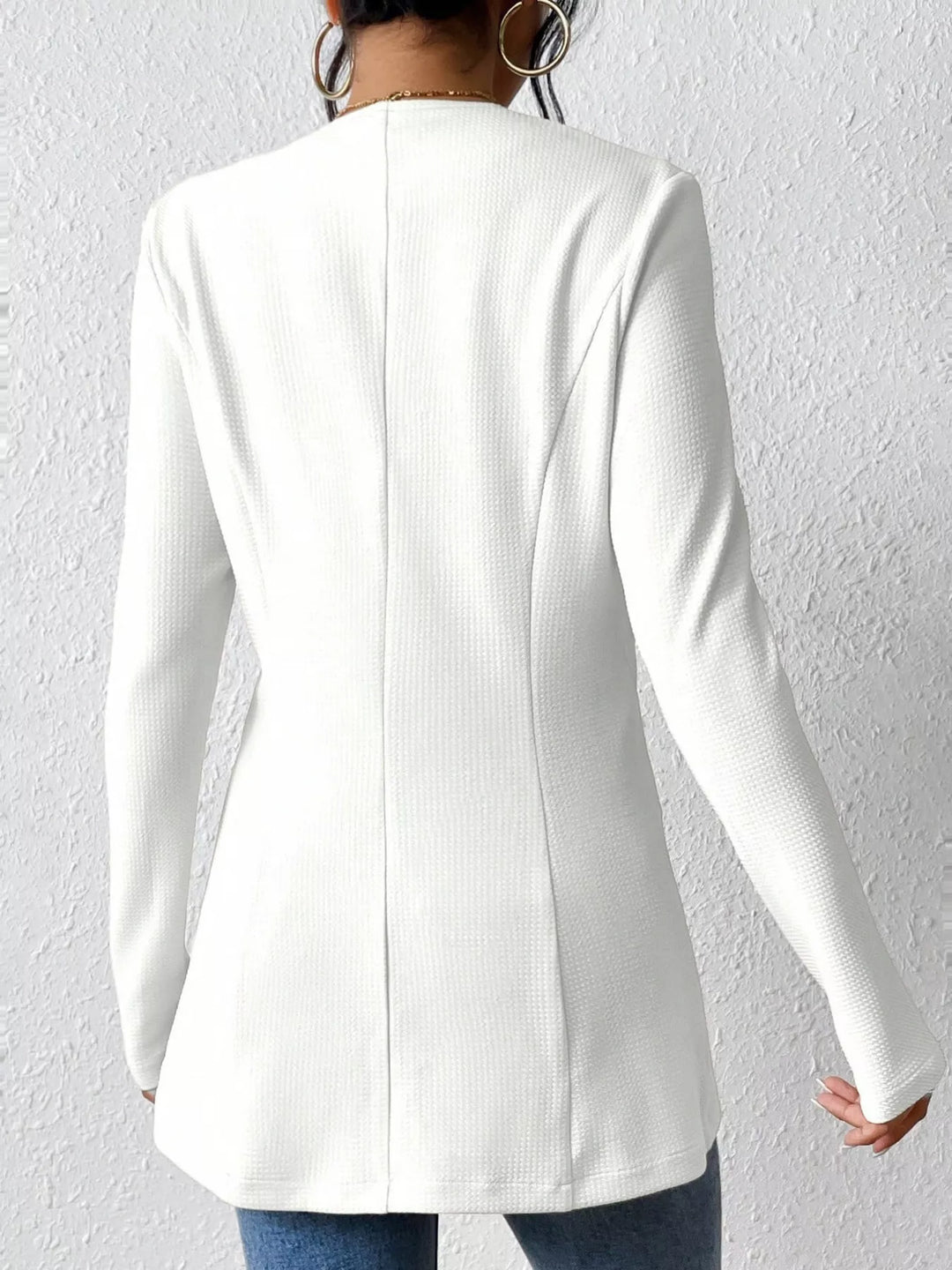 Back view of the white collarless blazer with center seam