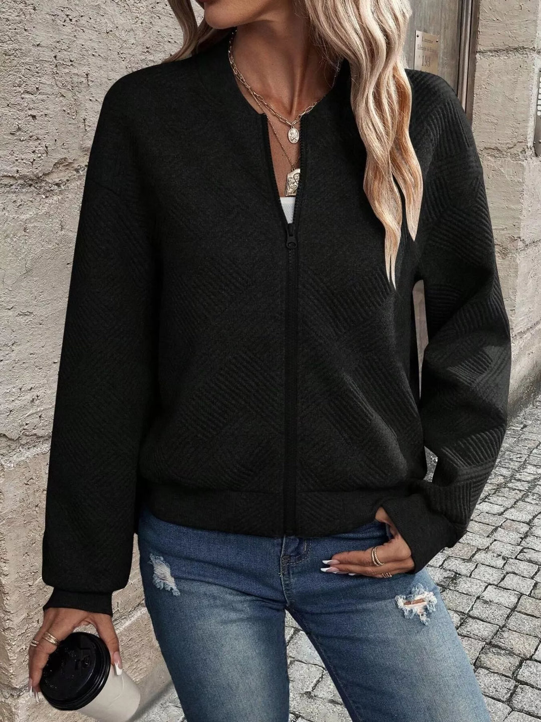 Black cropped bomber jacket with hand on hip, front view