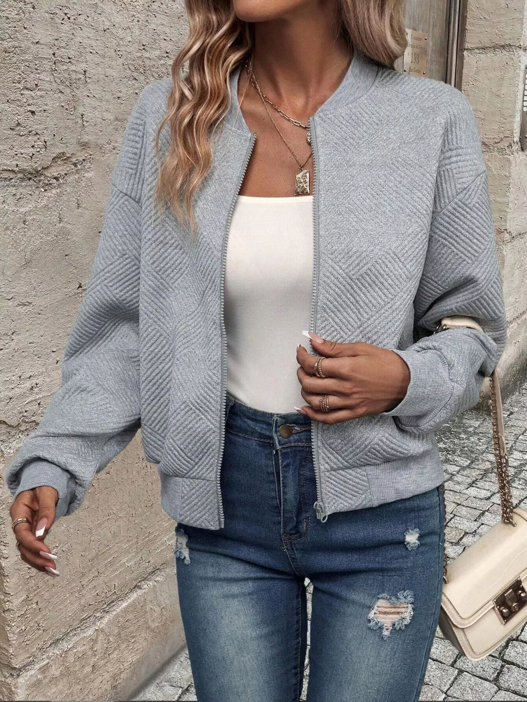 Light gray zip up bomber jacket, walking pose with the jacket open