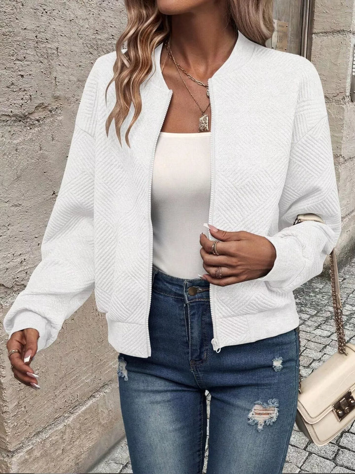 White cropped bomber jacket in a walking pose with jeans