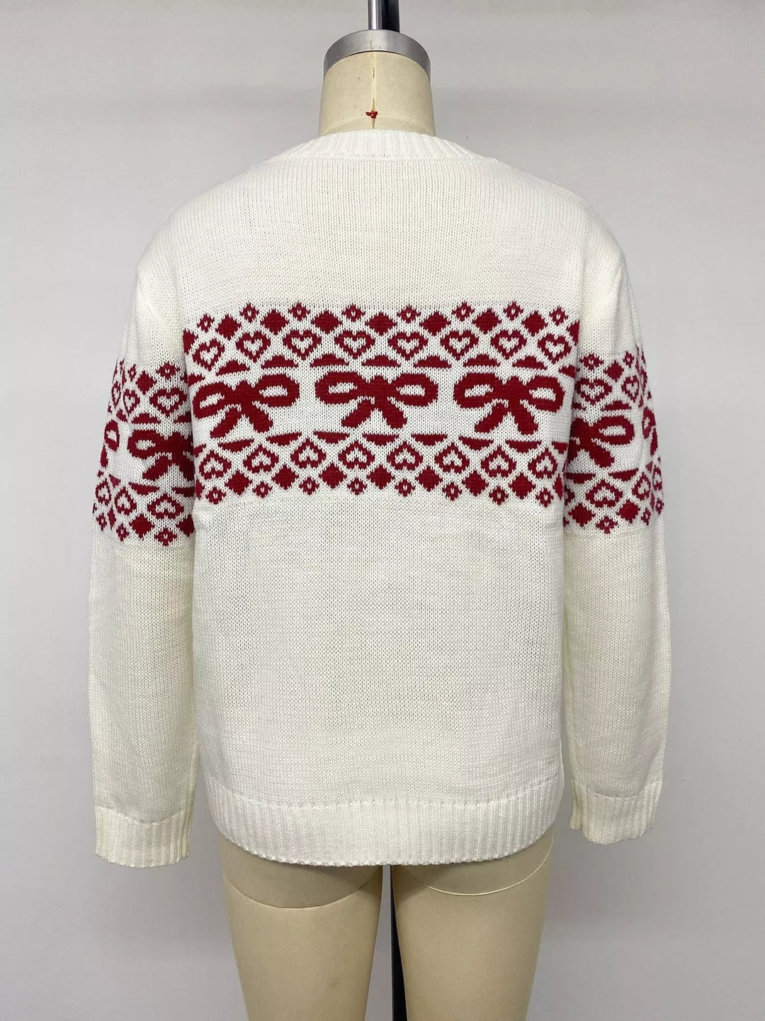 Back view of the white bow sweater on a mannequin showing the jacquard band