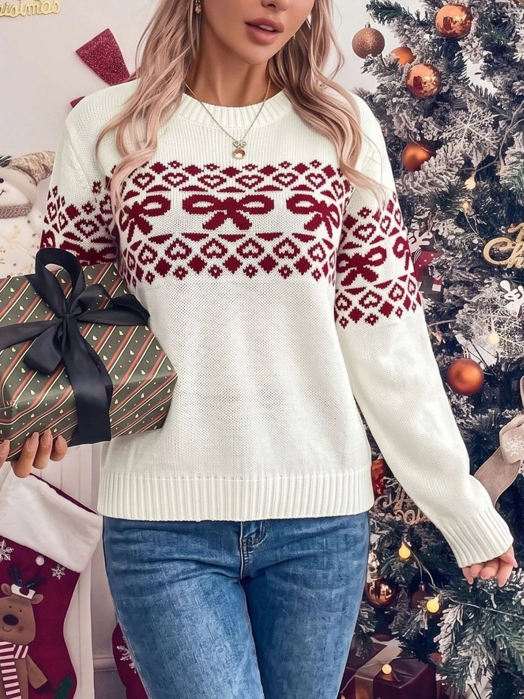 White bow sweater with long sleeves, carrying a wrapped gift with jeans