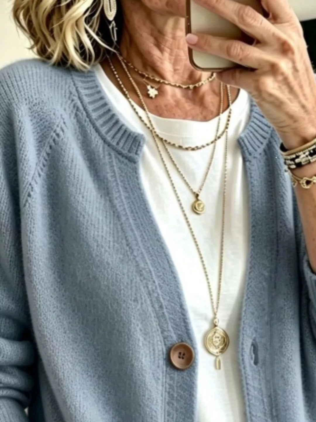 Close-up of the light blue cardigan crew neckline and wooden-look button