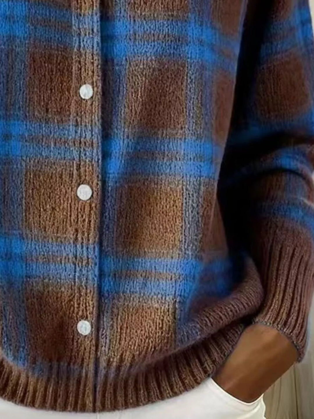 Detail of the brown blue plaid cardigan buttons and ribbed hem