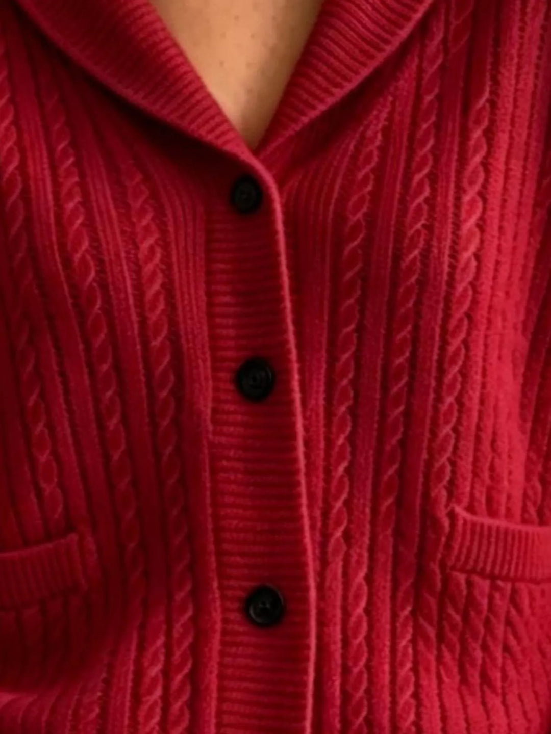 Close-up of burgundy cardigan cable knit texture, black buttons and patch pocket