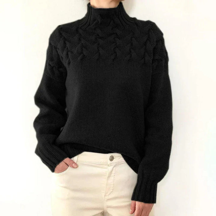 Model wearing the black cable knit sweater with a mock neck and twisted cable yoke