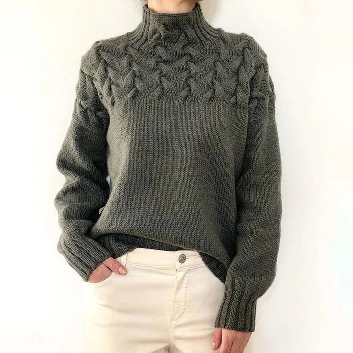 Model wearing the charcoal gray cable knit sweater with a mock neck and twisted cable yoke