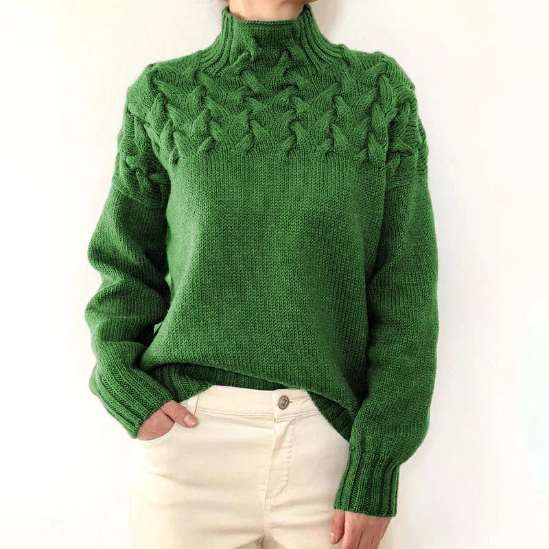 Model wearing the green cable knit sweater with a mock neck and twisted cable yoke