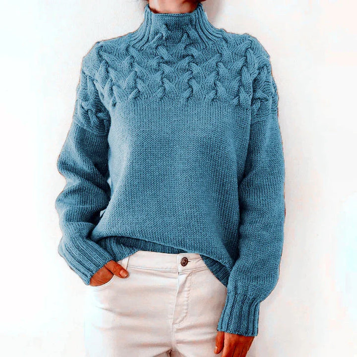 Model wearing the light blue cable knit sweater with a mock neck and twisted cable yoke