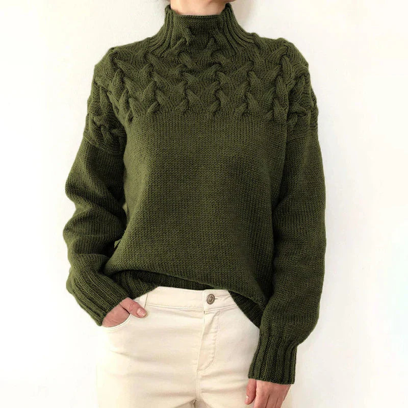 Model wearing the olive green cable knit sweater with a mock neck and twisted cable yoke
