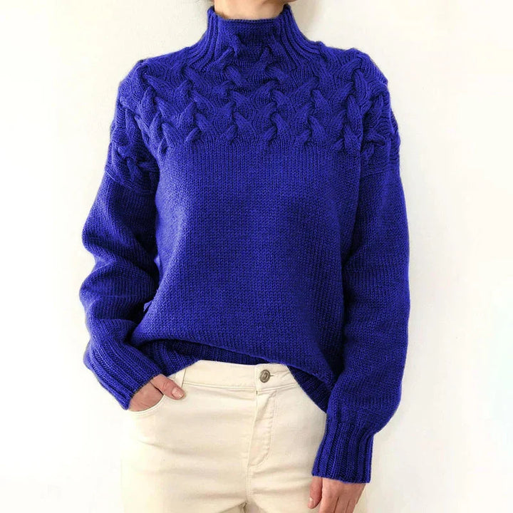 Model wearing the royal blue cable knit sweater with a mock neck and twisted cable yoke