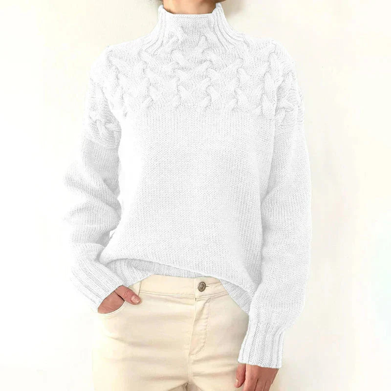 Model wearing the white cable knit sweater with a mock neck and twisted cable yoke