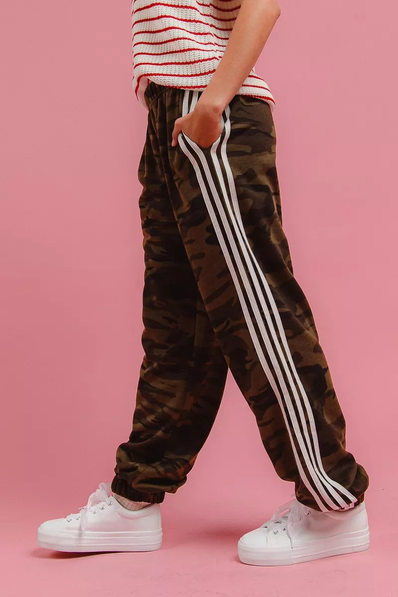 Side stripe detail on relaxed camo pants, angled walking pose