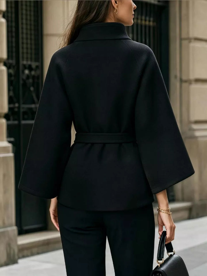 Asymmetric button tie belt stand collar in black, back view