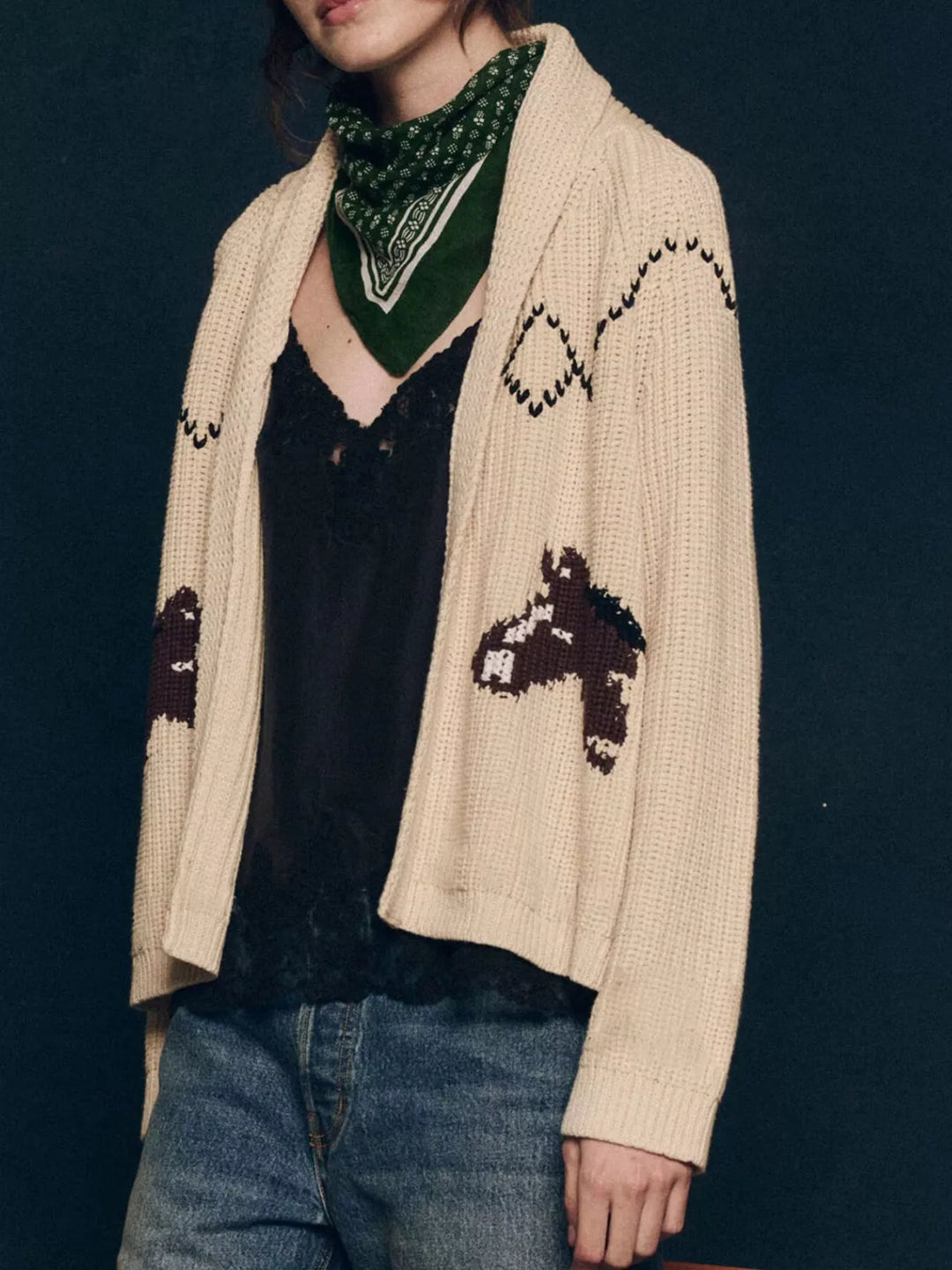 Cream open front cardigan with horse motifs, worn with a scarf and jeans