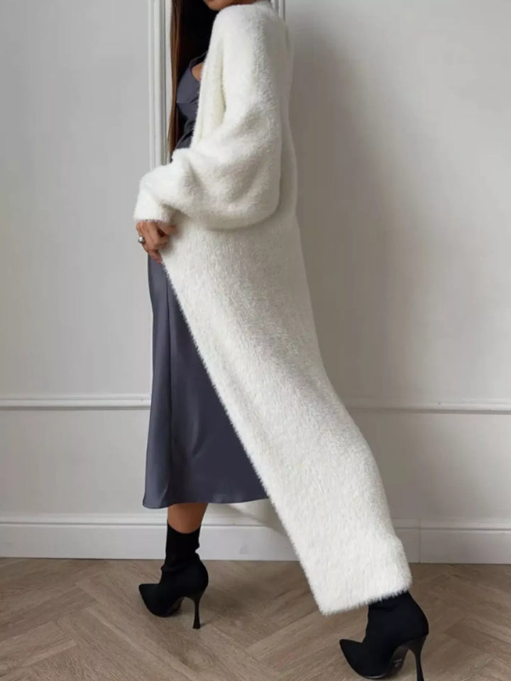 Side view of ivory longline fuzzy cardigan with black heeled boots