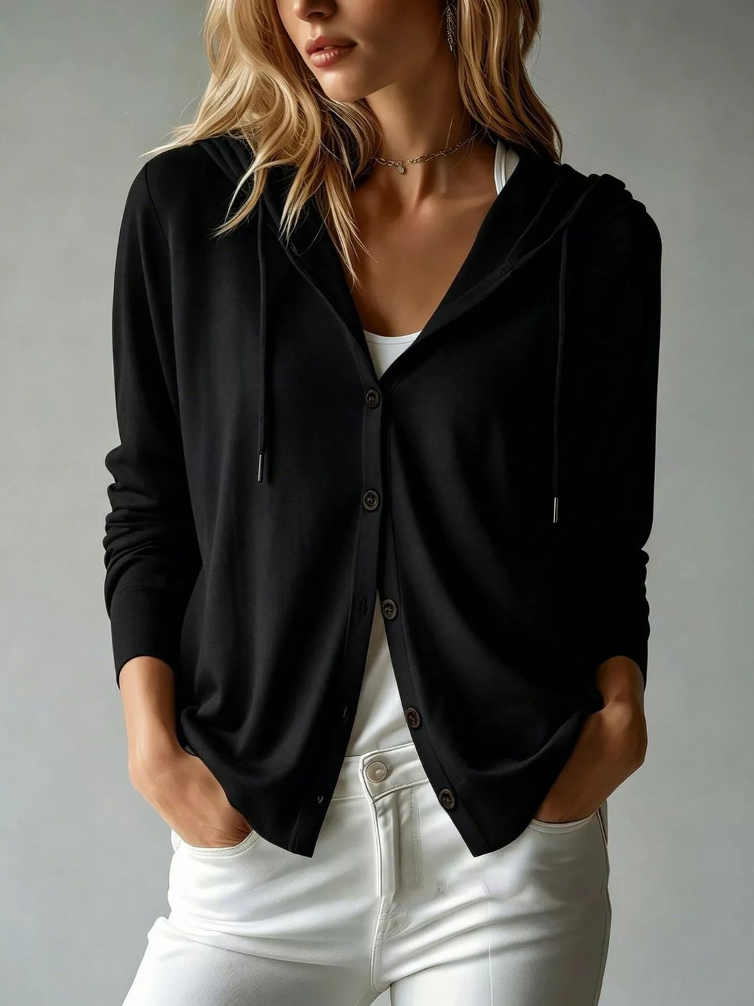 Black hooded cardigan with button front, worn over white jeans
