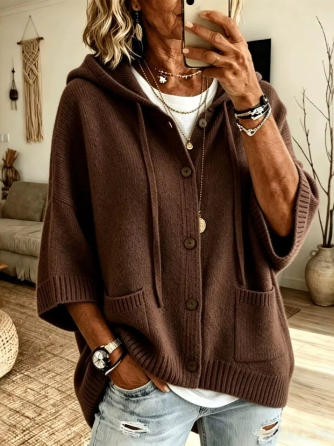 Brown hooded cardigan with button front and batwing sleeves, layered with a necklace