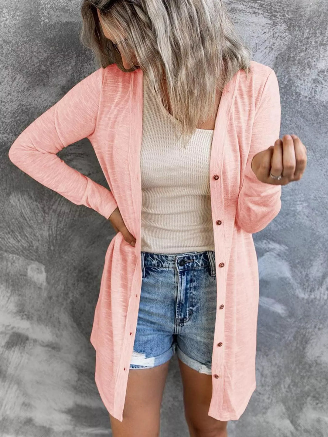 peach cardigan with button front and long sleeves worn over a tank
