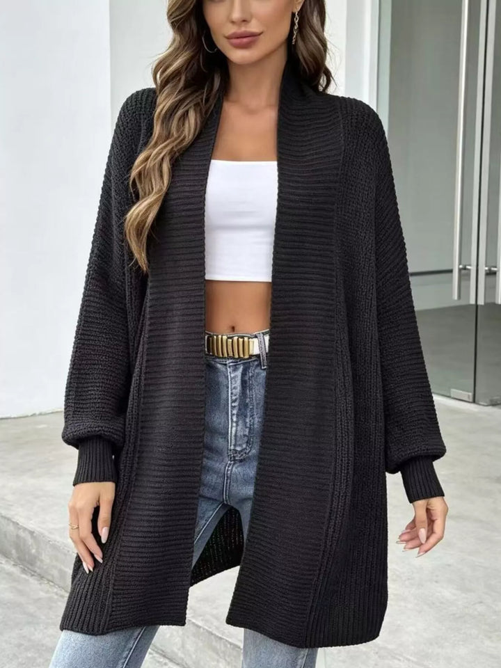 Black long cardigan with ribbed shawl collar worn open with jeans and a belt