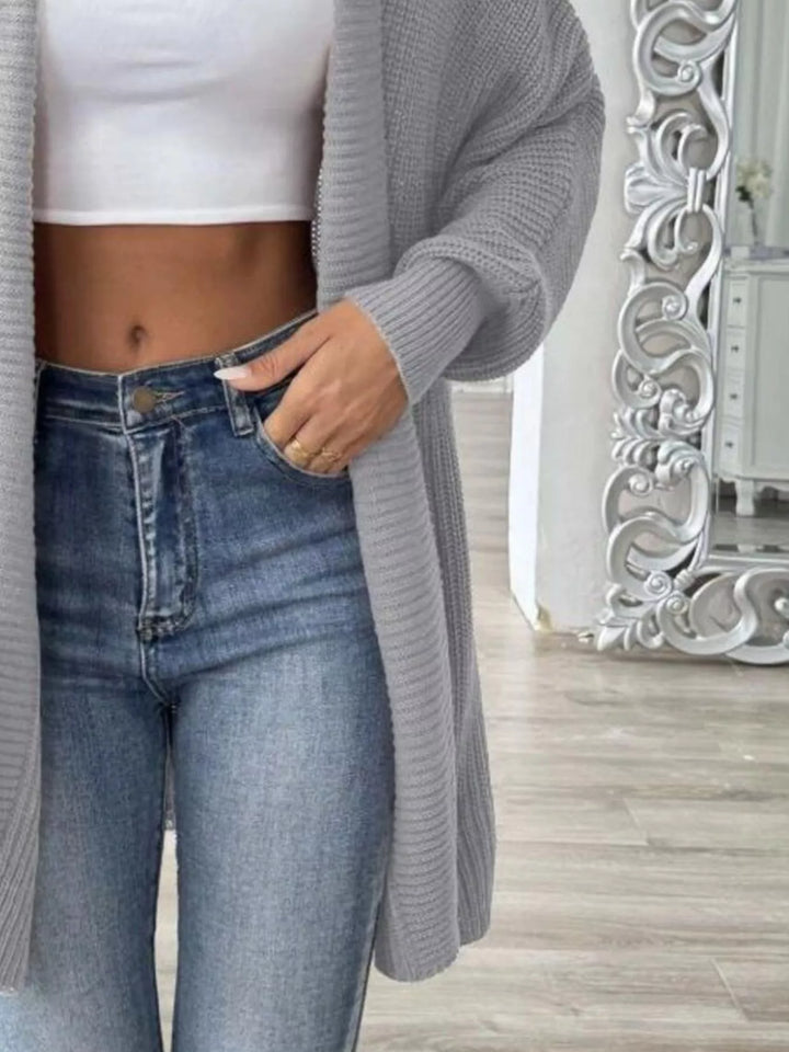 Close-up of the light gray open front cardigan with hand in jeans pocket