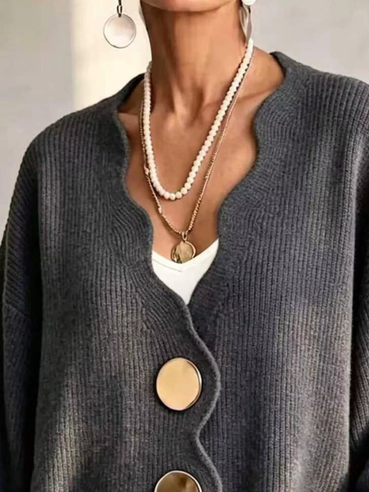 Close-up of the charcoal cardigan wavy neckline layered with pearl necklaces