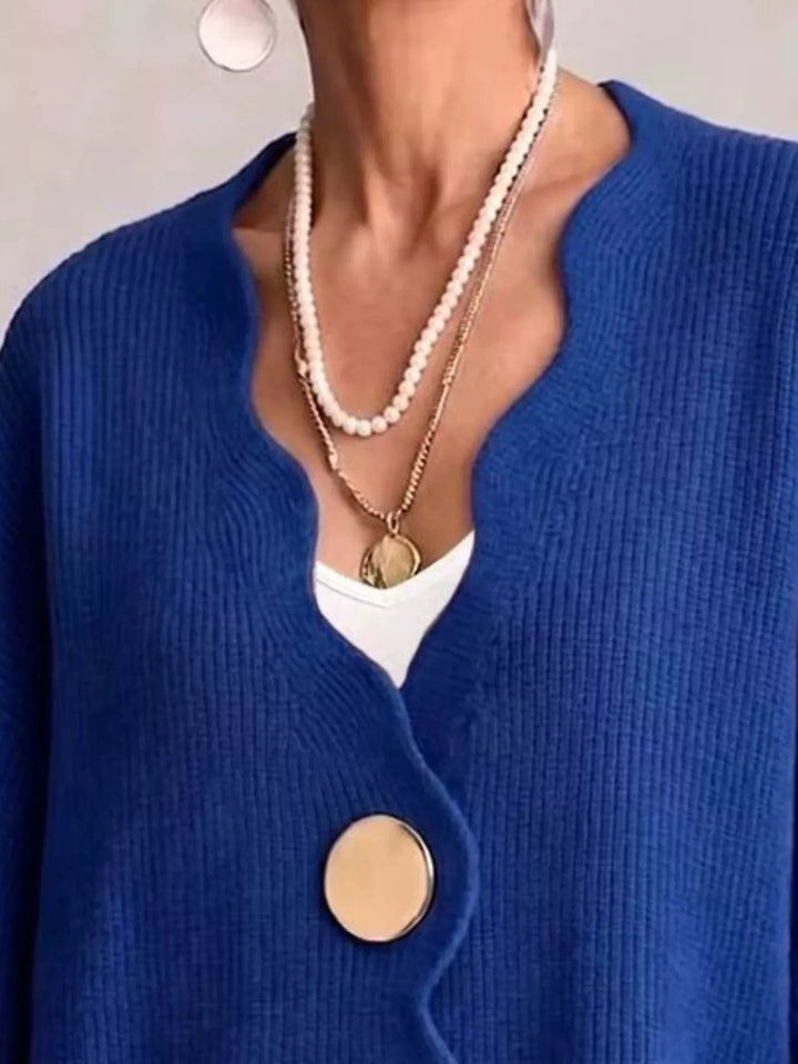 Close-up of the royal blue cardigan wavy neckline layered with pearl necklaces