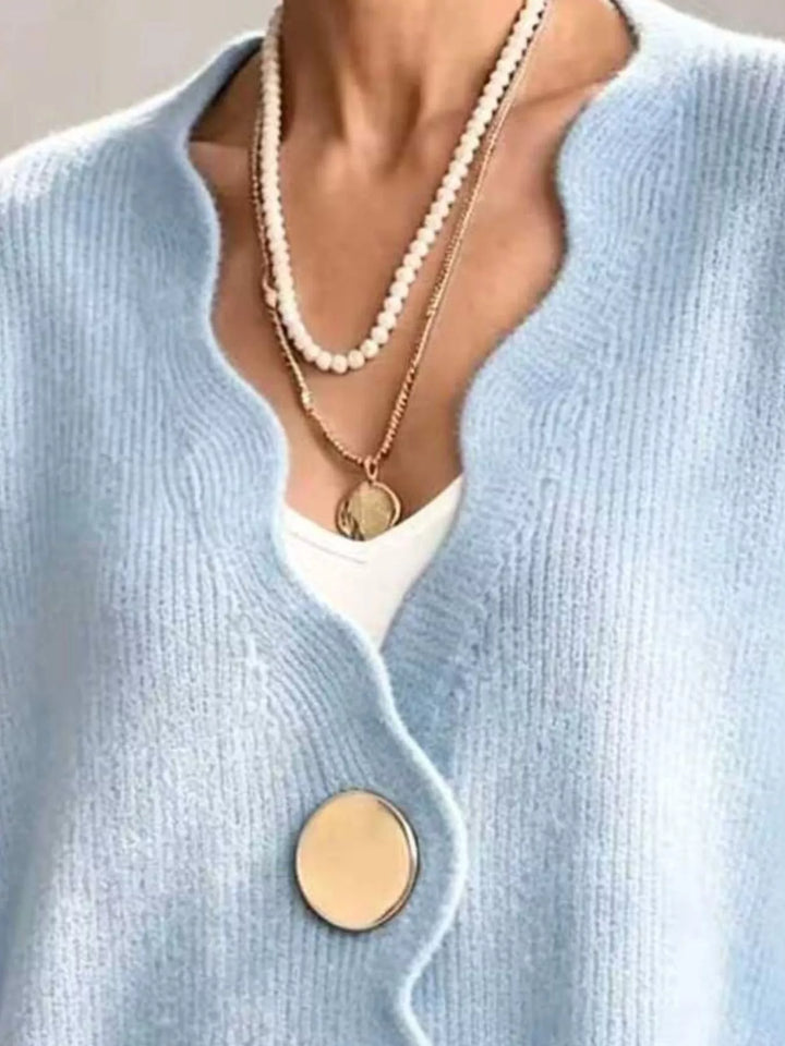 Close-up of the sky blue cardigan wavy neckline layered with pearl necklaces
